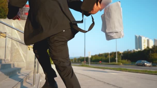 Неузнаваемый человек, бегущий на работу, разбрасывает документы по лестнице . — стоковое видео