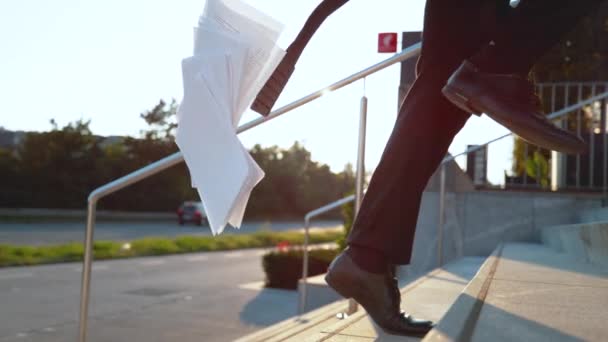 Медленное движение: молодой бизнесмен теряет бумажную работу во время бега по лестнице — стоковое видео