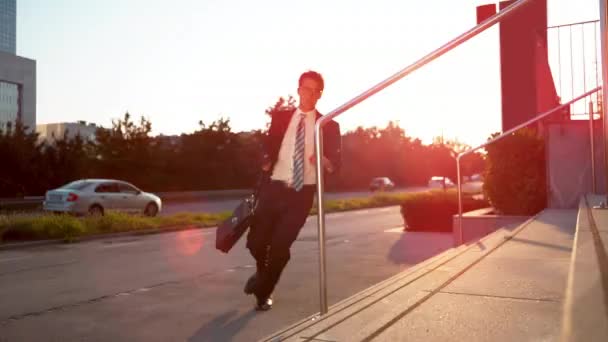 SUN FLARE: Young businessman running to an evening meeting and losing paperwork. — Stock Video