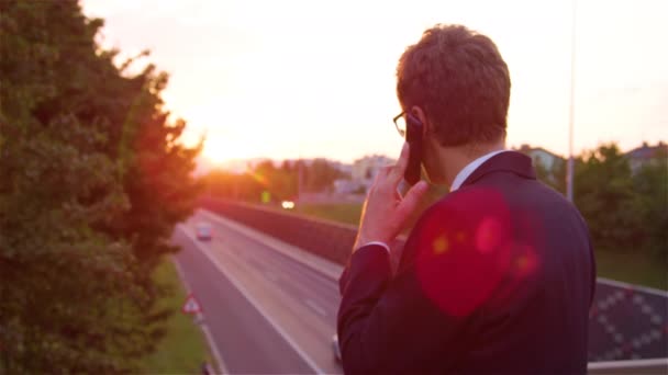 Nahaufnahme: Erfolgreicher Geschäftsmann telefoniert an sonnigem Abend — Stockvideo