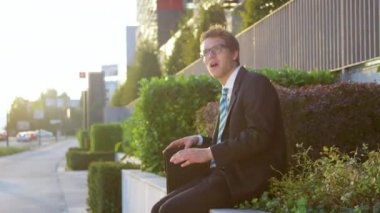 SUN FLARE: Excited young guy whistles on a sunny evening after getting a job.