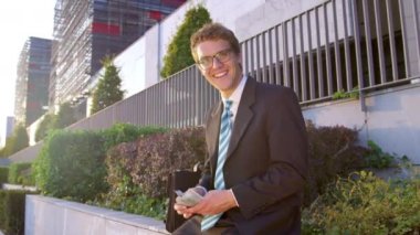 PORTRAIT: Cheerful businessman looking in the camera while counting his money.