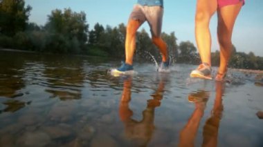 TIME REMAP: Fit couple running through idyllic forest and in the shallow stream.