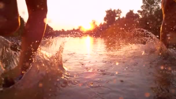 Czas Warp: Odpowiedni partnerzy treningowi biegają w odświeżającej wodzie rzecznej w kierunku zachodu słońca. — Wideo stockowe