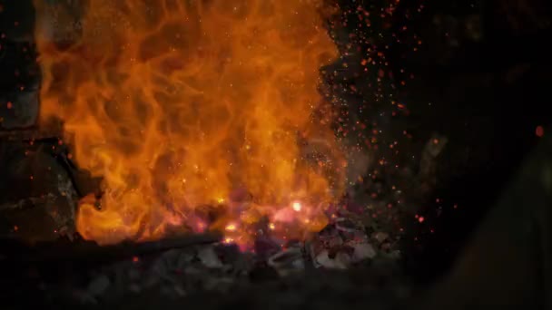 SLOW MOTION, MACRO: Metal poker stirs the glowing embers inside a brick oven. — Stock Video