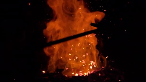 宏观：火花从燃烧的余焰中飞走，因为它们被一根杆子搅动着 — 图库视频影像