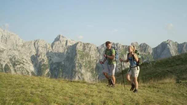 Movimiento lento: Deportivo joven pareja caucásica trekking en las montañas escénicas . — Vídeo de stock