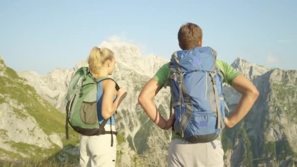 Pomalý pohyb: veselý pár plácnutí po pěší turistice až na vrchol hory. — Stock video