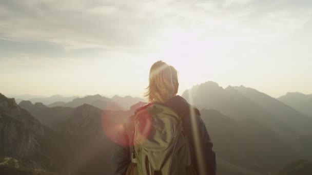 LENS FLARE: Trekker ünnepli eléri hegy tetején egy napsütéses nyári napon. — Stock videók