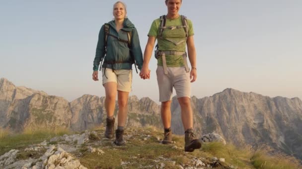 Närbild: Leende ung vandrare par hålla händer när du går utför. — Stockvideo