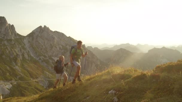 スローモーション:美しい山々でハイキングを楽しむ幸せな女性と男性. — ストック動画