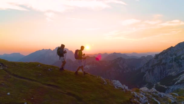 FLARE DE LA LENTE: Mujer activa y novio descendiendo por la montaña al amanecer . — Vídeo de stock