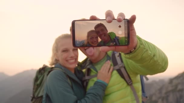 CHIUDI, DOF: Coppia escursionista spensierata che fa facce divertenti mentre si fa un selfie . — Video Stock