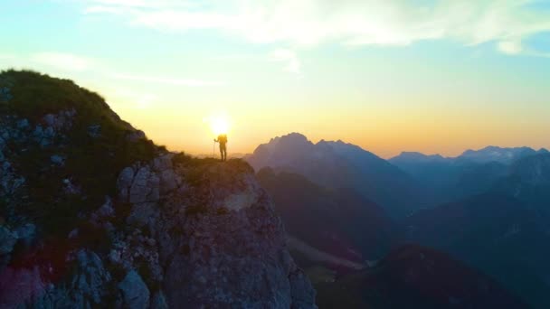 SILHOUETTE: Oigenkännlig manlig turist vandring i Alperna observera solnedgången. — Stockvideo