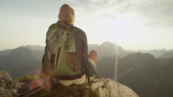 LENS FLARE: Unrecognizable trekker girl relaxing in picturesque sunny mountains. — Stock Video