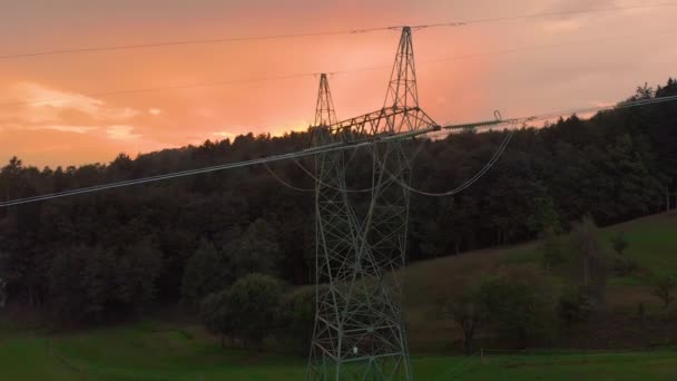DRONE Voando sobre uma torre de alta eletricidade e fios que atravessam o campo — Vídeo de Stock