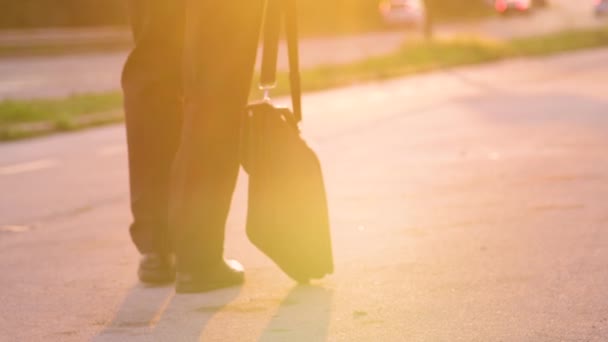 Kapanış: Depresyondaki işadamı güneşli bir akşamda eve yürürken sallanan evrak çantası — Stok video