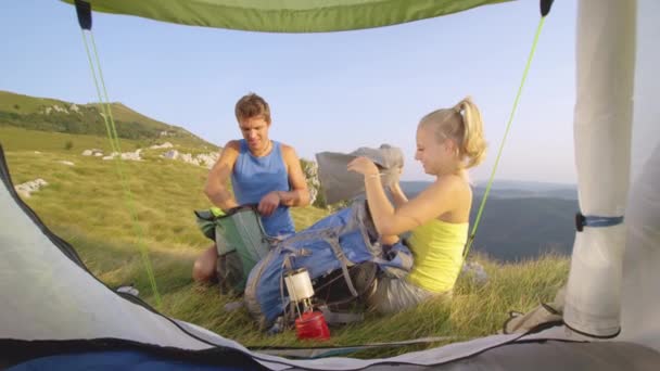 閉じる:アルプスでのバッカーハイキングは、テントによって機器をアンパック. — ストック動画