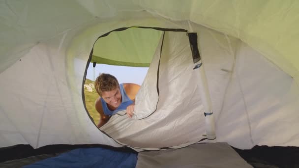 Yakın çekim: neşeli erkek turist çadırı açıyor ve kız arkadaşıyla içeri giriyor — Stok video