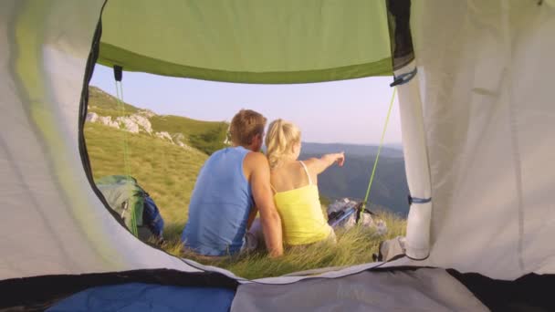 Sluiten omhoog: Jonge blonde vrouw tonen de prachtige bergen aan haar vriendje. — Stockvideo