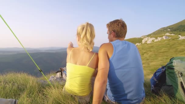 LOW MOTION: Menina de cabelos loiros sentada com seu namorado e observando a natureza . — Vídeo de Stock
