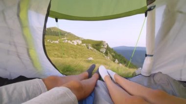 Slow Motion: Genç yürüyüşçüler çadırlarında dinlenirken ayak parmaklarını oynatıyorlar.