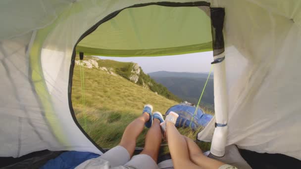 STÄNGA UPP: Oigenkännliga vandrare som bär gymnastikskor ligger i sitt tält i Alperna. — Stockvideo