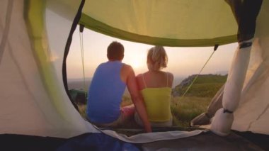 Altın sabah güneşleri çadırın önünde oturan çifte parlıyor..