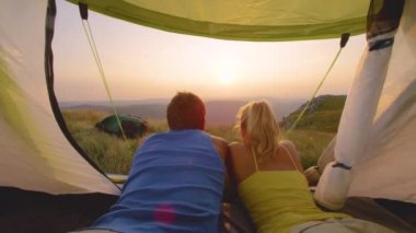 Yakından: Alplerde kamp yapan tanınmayan çift güneşin doğuşunu seyrediyor.