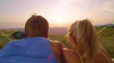 Lens: Yürüyüş yapan çift çadırlarında uzanıyor ve altın gün batımını izliyorlar.