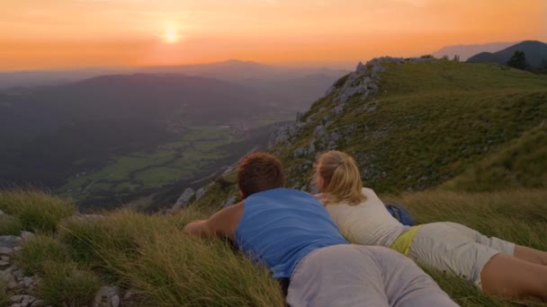 Κοντινό πλάνο: Νέοι backpackers που βρίσκονται στο γρασίδι και βλέποντας την όμορφη φύση — Αρχείο Βίντεο