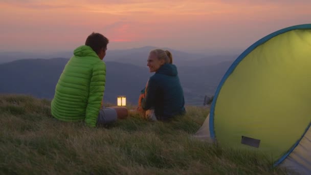 가까이 감: 알프스 산맥에서 평화 로운 저녁을 즐기며 캠핑 여행을 하고 있는 젊은 부부 — 비디오
