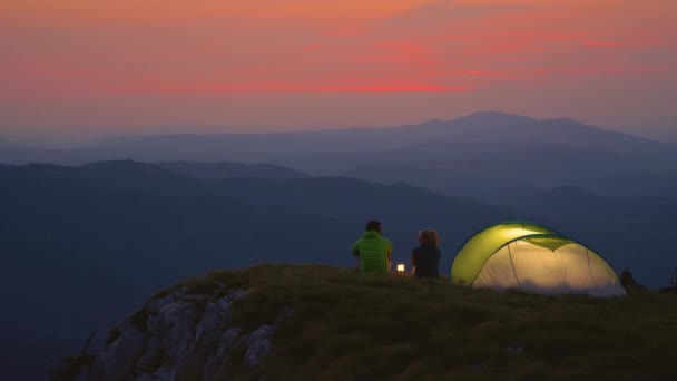 MOCIÓN LENTA: Pareja de excursionistas hablando junto a la linterna en una fría mañana de verano . — Vídeo de stock