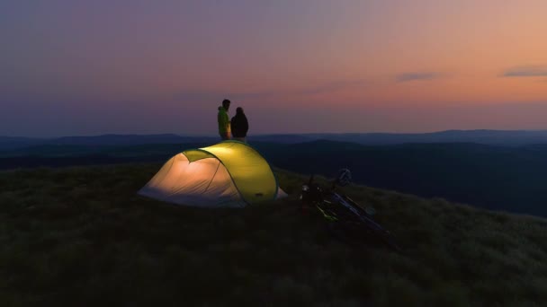 AERIAL: Young man and woman enjoying a date in the mountains on calm morning. — Stok video