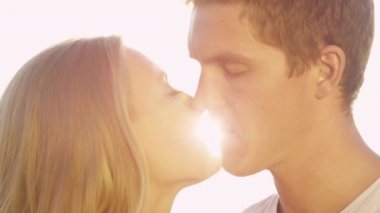 Slow Motion: Genç beyaz erkek ve kadın öpüşüp uzaktan bakıyorlar.