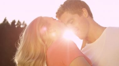 Mutlu erkek ve kadın bir yaz günü birbirlerini alnından öperler..