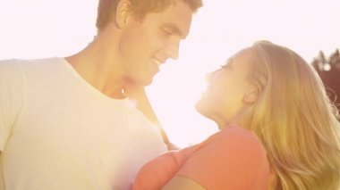 Yakından: Yakışıklı adam eğilir ve güzel kız arkadaşını kucağında öper..