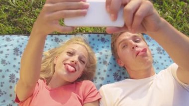 Kapat: Sosyal medya için selfie çekerken tuhaf suratlar yapan aptal çift.