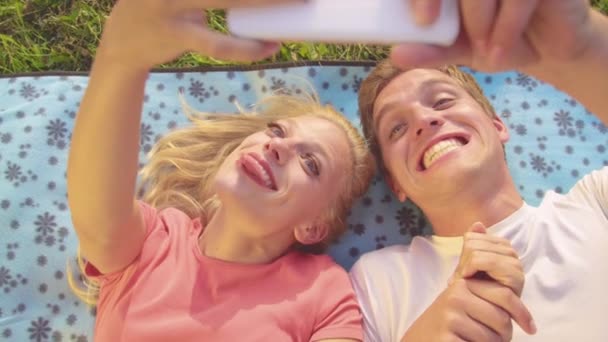 Zeitlupe: Aufgeregte junge Frau und Mann machen lustige Gesichter und machen Selfies. — Stockvideo
