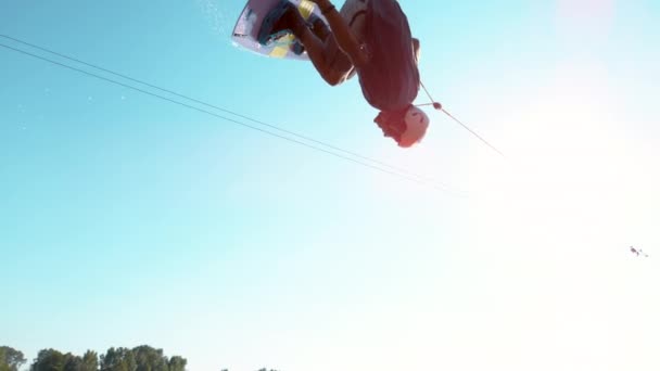 SLOW MIION: Спортивный серфер чувак делает обратный сальто, когда летит по небу . — стоковое видео