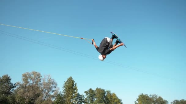 Slow Motion: Atletisk man gör en cool spinning backflip medan du vaknar. — Stockvideo