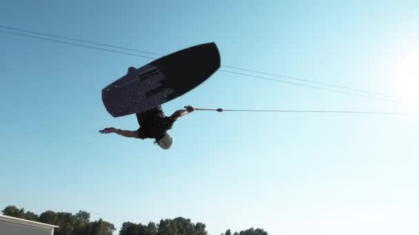 SUN FLARE: Кинематографический снимок атлетического туриста, делающего трюки во время бодрствования . — стоковое видео