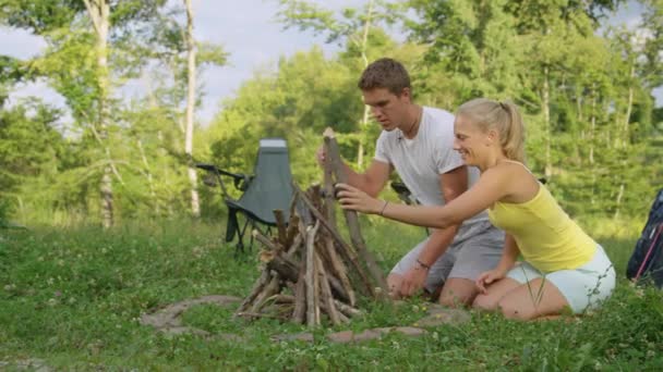 Slow Motion: Jonge man en vrouw kussen na het bouwen van een kampvuur. — Stockvideo