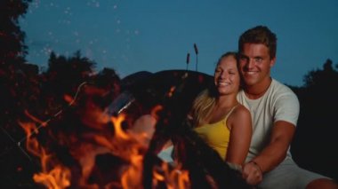 COPY SPACE: Happy couple sitting by the campfire on a romantic summer evening.
