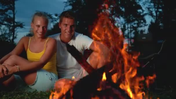 Time Remap, zbliżenie: Szczęśliwy podróżnik para przytulanie i patrząc na ognisko — Wideo stockowe