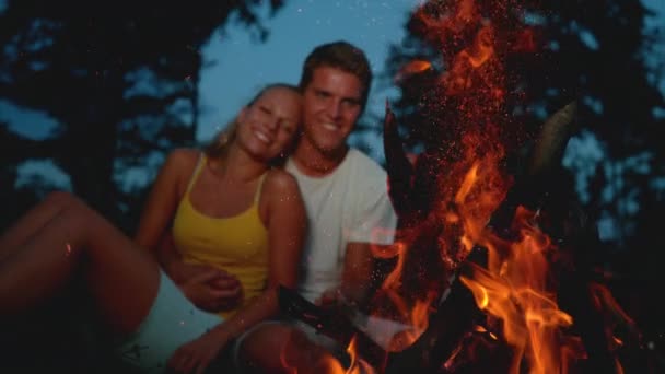 スローモーション, Dof:若いカップルの抱きしめと燃焼キャンプファイヤーを見て. — ストック動画