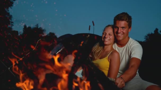 COPY SPACE: Casal feliz sentado na fogueira em uma noite romântica de verão . — Vídeo de Stock