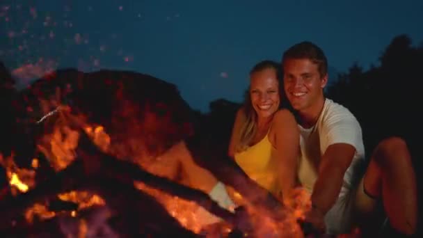ВРЕМЯ: Молодой парень и девушка наслаждаются романтической ночью у костра — стоковое видео