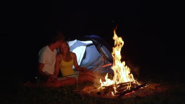 FERMETURE : Joyeux couple campant dans les saucisses rôties sauvages sur un feu de camp . — Video