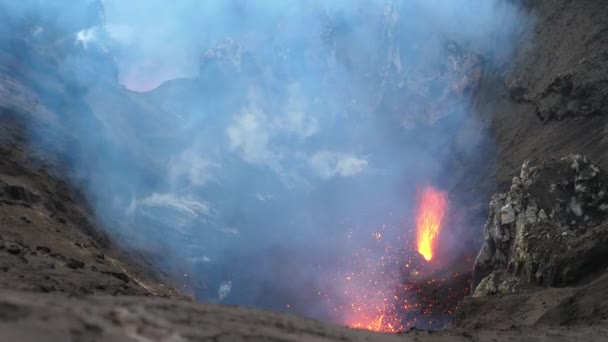 Nahaufnahme: Aktiver Vulkan im Pazifik spuckt orange glühende Lava aus. — Stockvideo